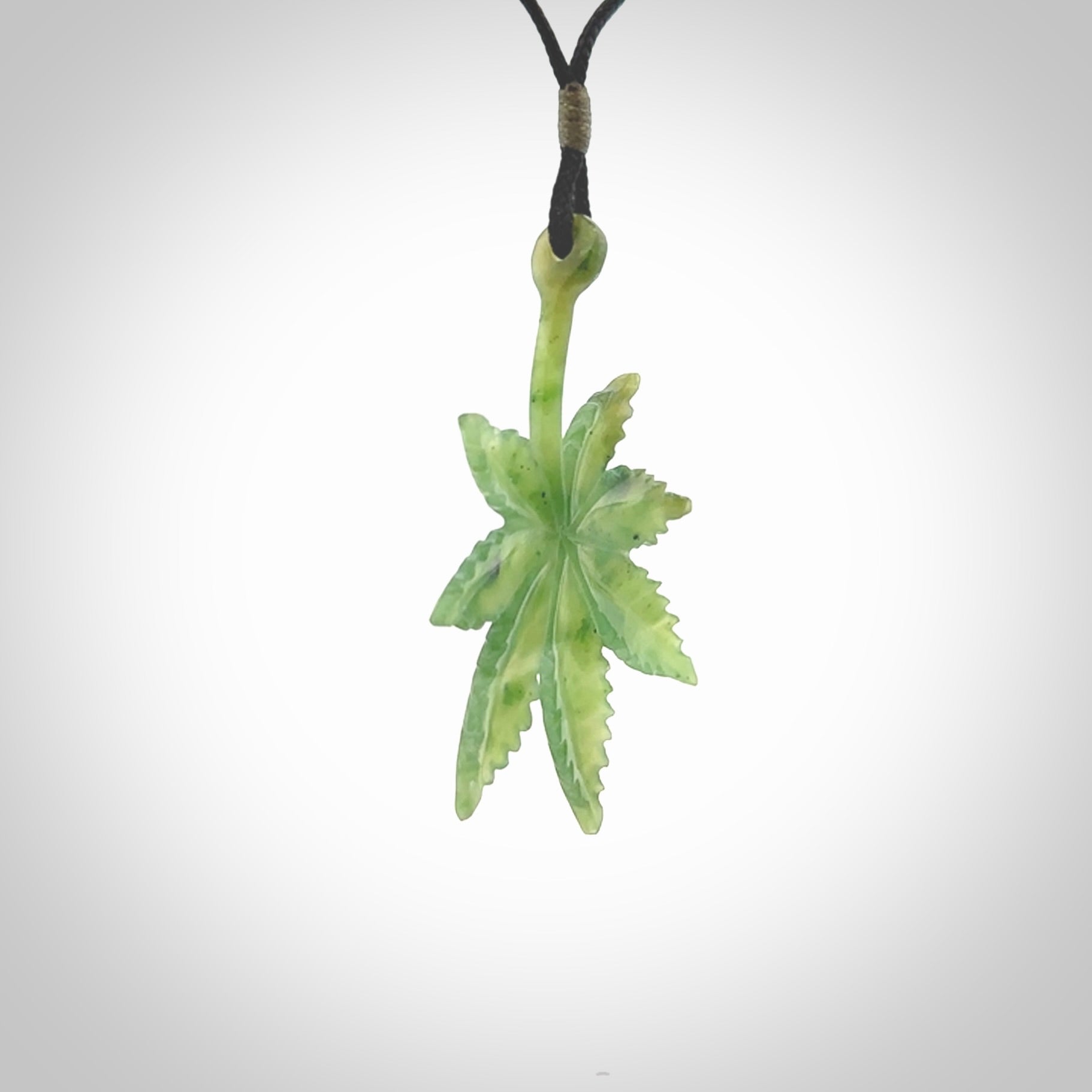 Cannabis Leaf Jade Stone pendant. Handmade jade Cannabis flower jewellery made by NZ Pacific and for sale online. Jade stone Marijuana leaf pendant for men and women. Unique art to wear from NZ Pacific. Delivered on an adjustable black cord.