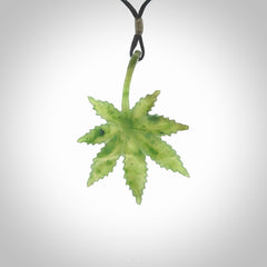 Cannabis Leaf Jade Stone pendant. Handmade jade Cannabis flower jewellery made by NZ Pacific and for sale online. Jade stone Marijuana leaf pendant for men and women. Unique art to wear from NZ Pacific. Delivered on an adjustable black cord.