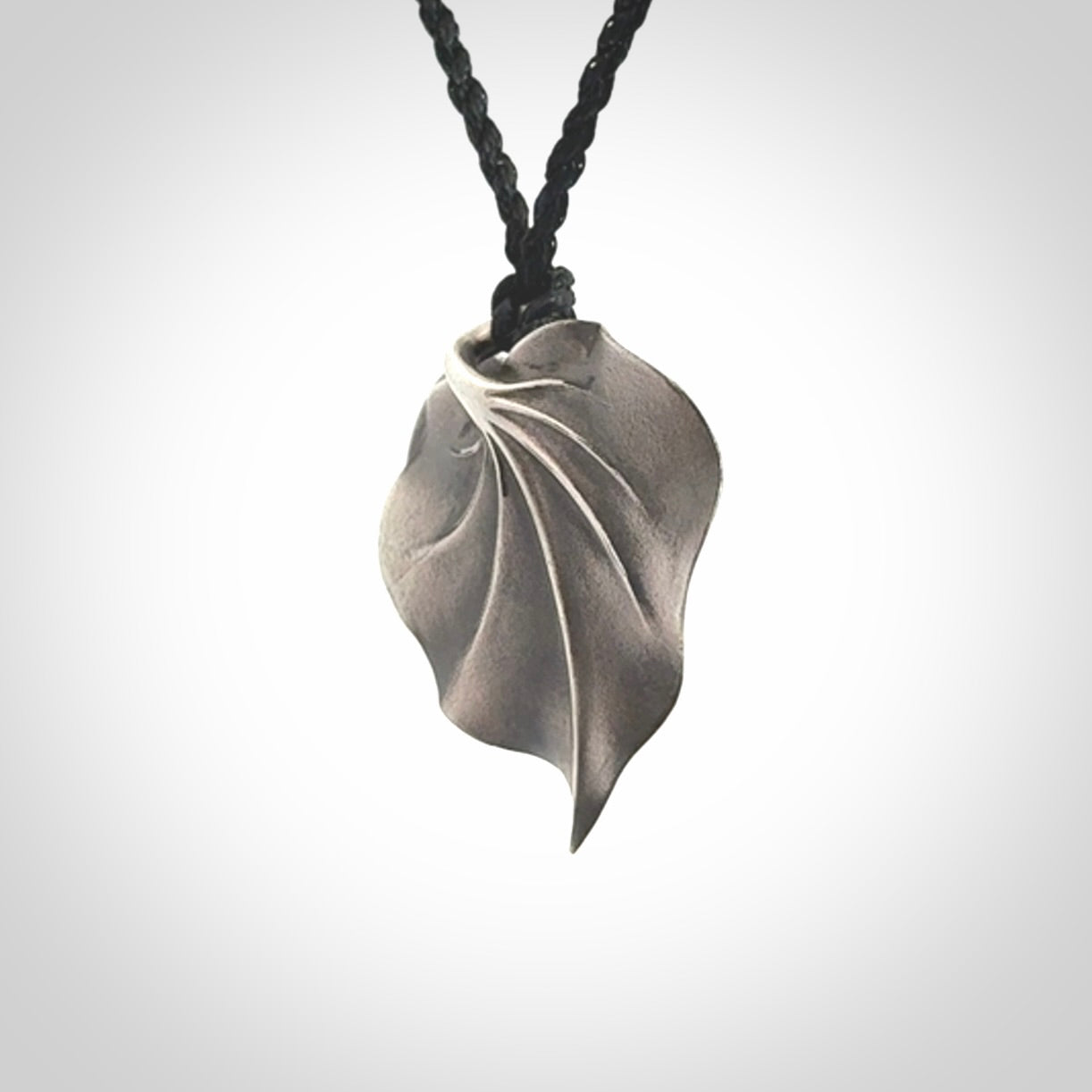 This is a hand carved Sterling Silver Kawakawa leaf pendant with New Zealand flower Jade insert. This is a medium sized necklace and is provided with an adjustable black cord.