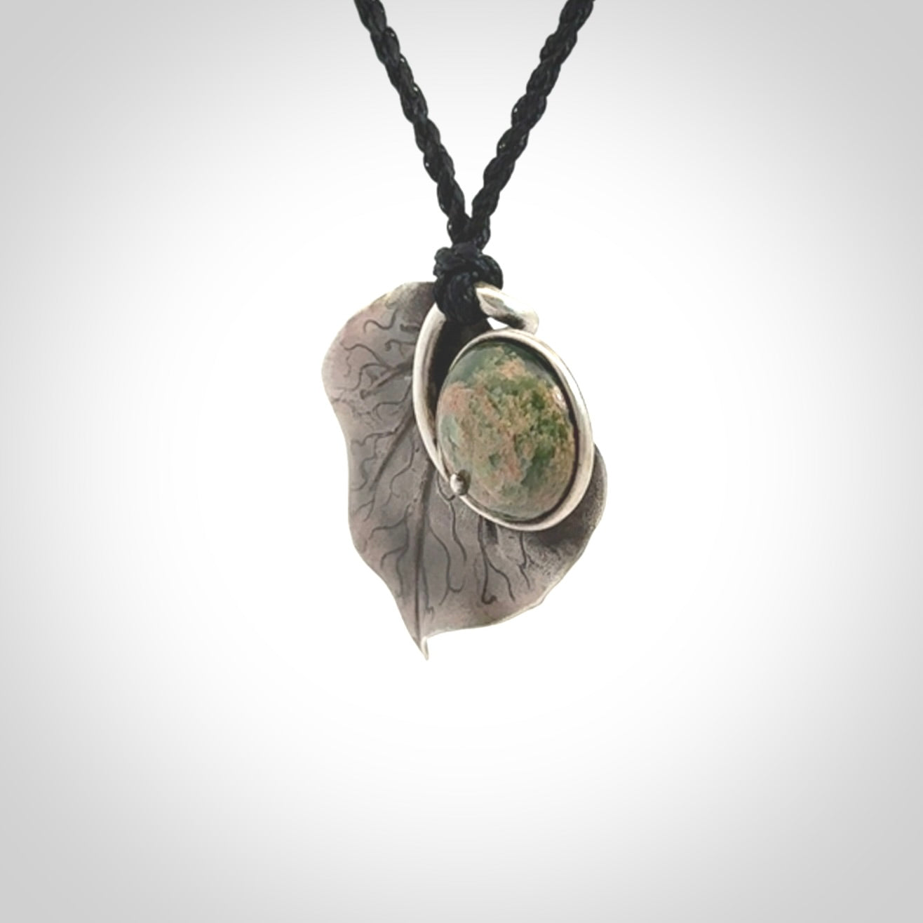 This is a hand carved Sterling Silver Kawakawa leaf pendant with New Zealand flower Jade insert. This is a medium sized necklace and is provided with an adjustable black cord.