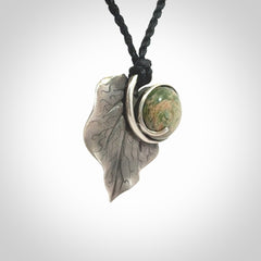 This is a hand carved Sterling Silver Kawakawa leaf pendant with New Zealand flower Jade insert. This is a medium sized necklace and is provided with an adjustable black cord.