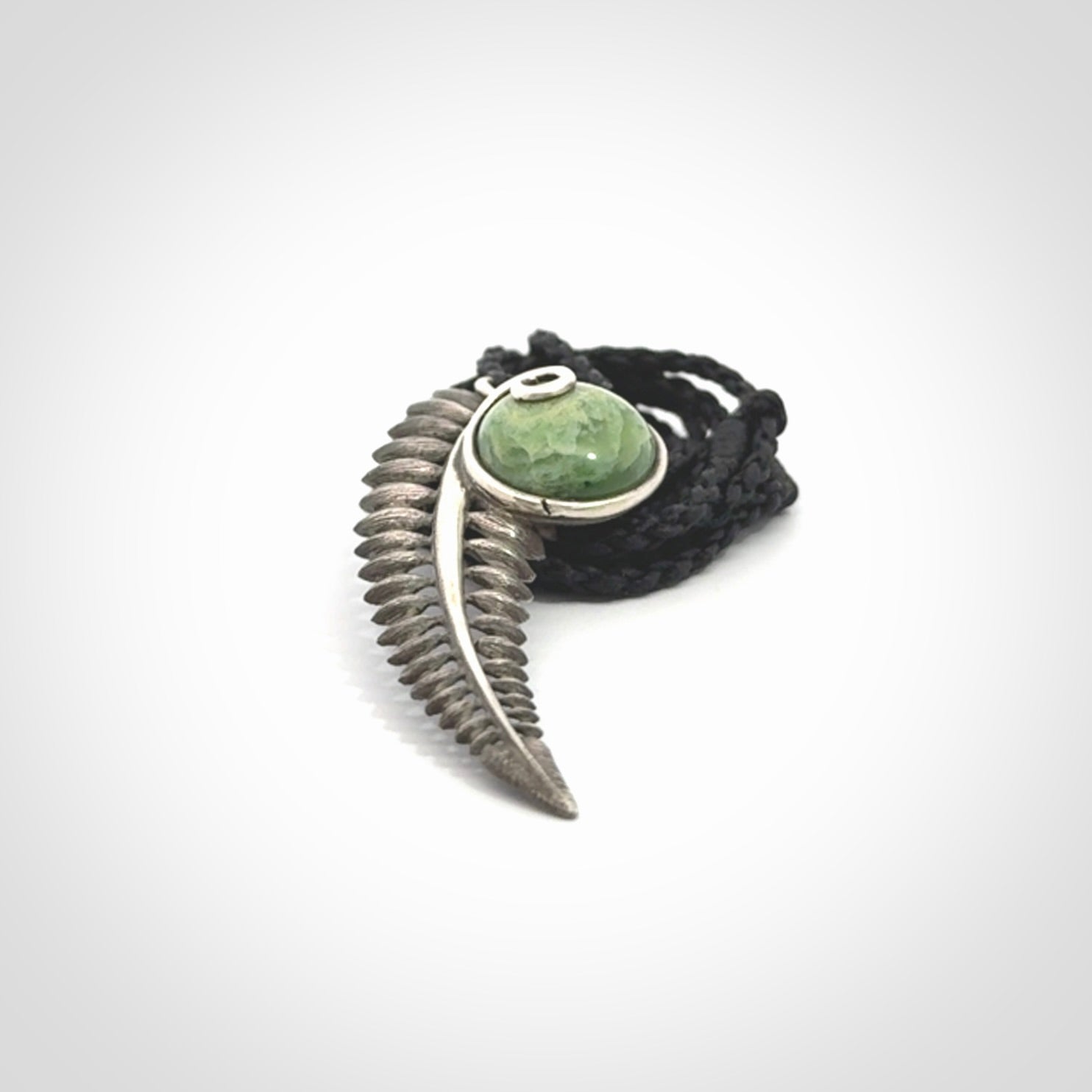 This is a hand carved Sterling Silver Fern leaf pendant with New Zealand flower Jade insert. This is a medium sized necklace and is provided with an adjustable black cord.