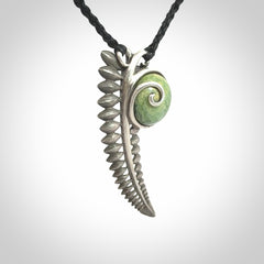 This is a hand carved Sterling Silver Fern leaf pendant with New Zealand flower Jade insert. This is a medium sized necklace and is provided with an adjustable black cord.