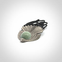 This is a hand carved Sterling Silver Fern fantail pendant with New Zealand Jade insert. This is a medium sized necklace and is provided with an adjustable black cord.