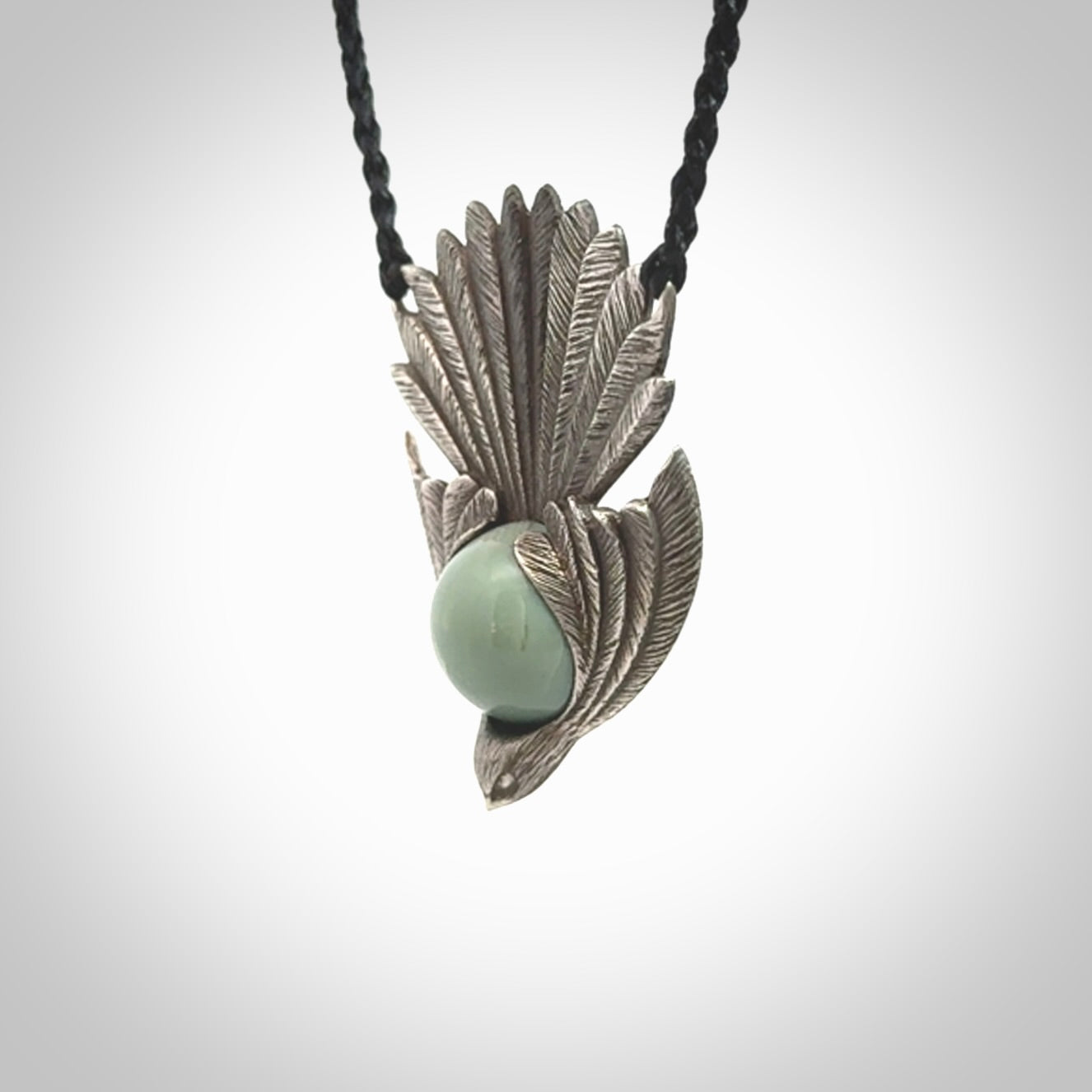 This is a hand carved Sterling Silver Fern fantail pendant with New Zealand Jade insert. This is a medium sized necklace and is provided with an adjustable black cord.