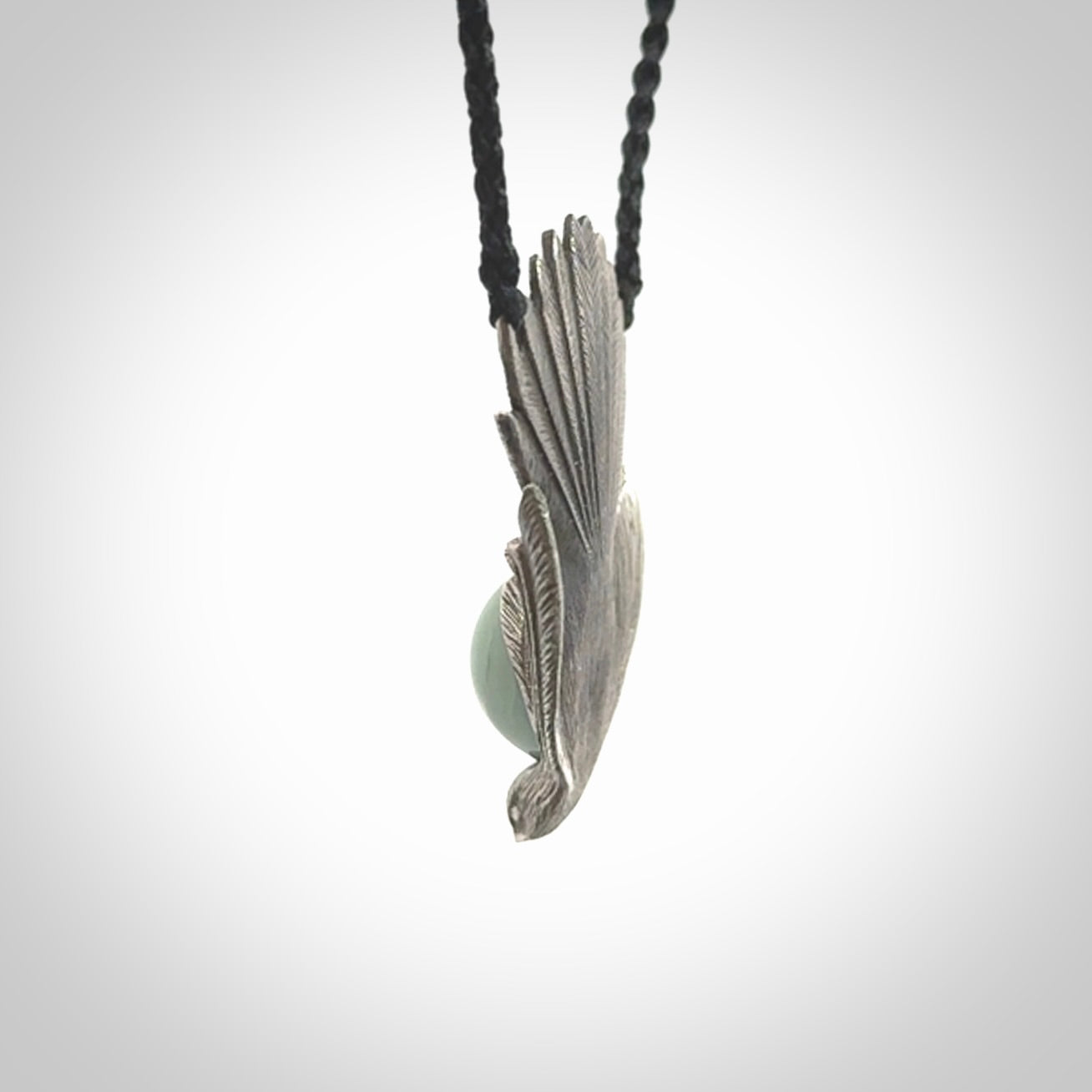 This is a hand carved Sterling Silver Fern fantail pendant with New Zealand Jade insert. This is a medium sized necklace and is provided with an adjustable black cord.