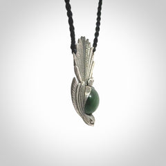 This is a hand carved Sterling Silver Fern fantail pendant with New Zealand Jade insert. This is a medium sized necklace and is provided with an adjustable black cord.