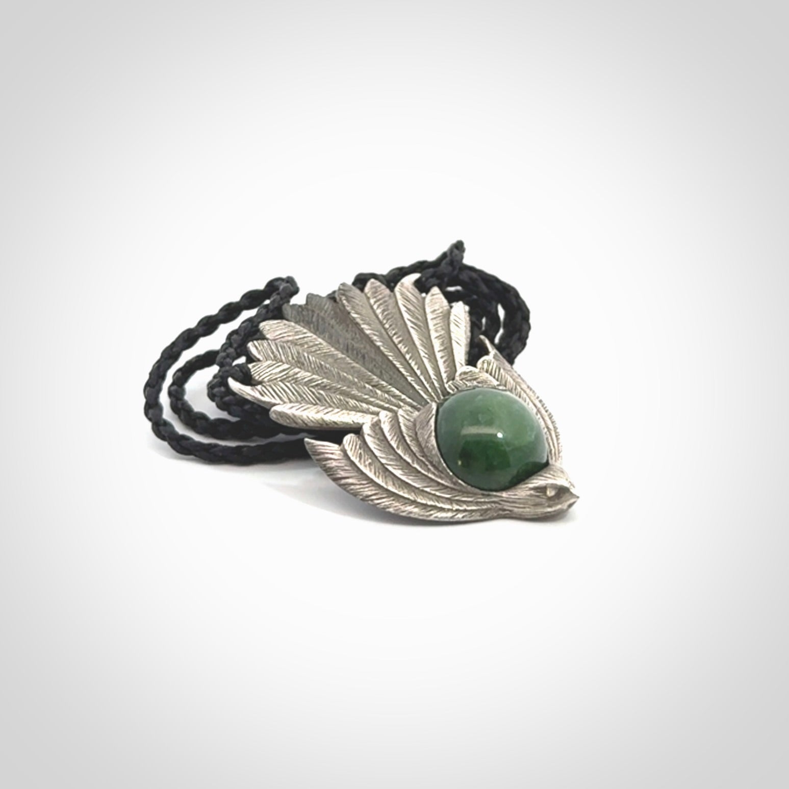 This is a hand carved Sterling Silver Fern fantail pendant with New Zealand Jade insert. This is a medium sized necklace and is provided with an adjustable black cord.