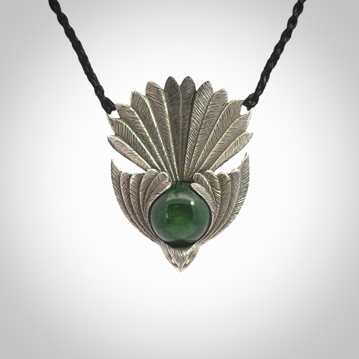 This is a hand carved Sterling Silver Fern fantail pendant with New Zealand Jade insert. This is a medium sized necklace and is provided with an adjustable black cord.