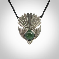 This is a hand carved Sterling Silver Fern fantail pendant with New Zealand Jade insert. This is a medium sized necklace and is provided with an adjustable black cord.