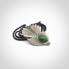 This is a hand carved Sterling Silver Fern fantail pendant with New Zealand Jade insert. This is a medium sized necklace and is provided with an adjustable black cord.