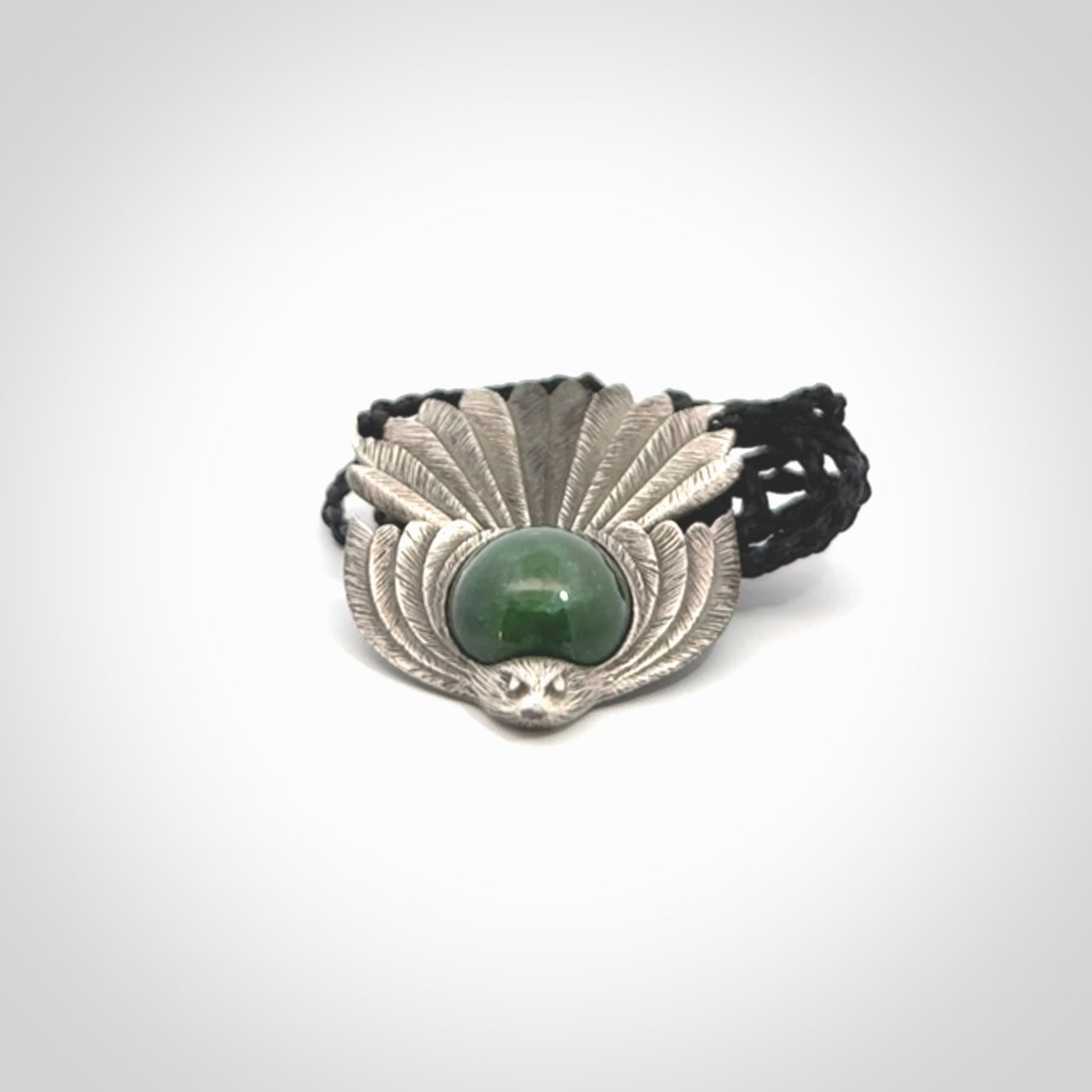 This is a hand carved Sterling Silver Fern fantail pendant with New Zealand Jade insert. This is a medium sized necklace and is provided with an adjustable black cord.
