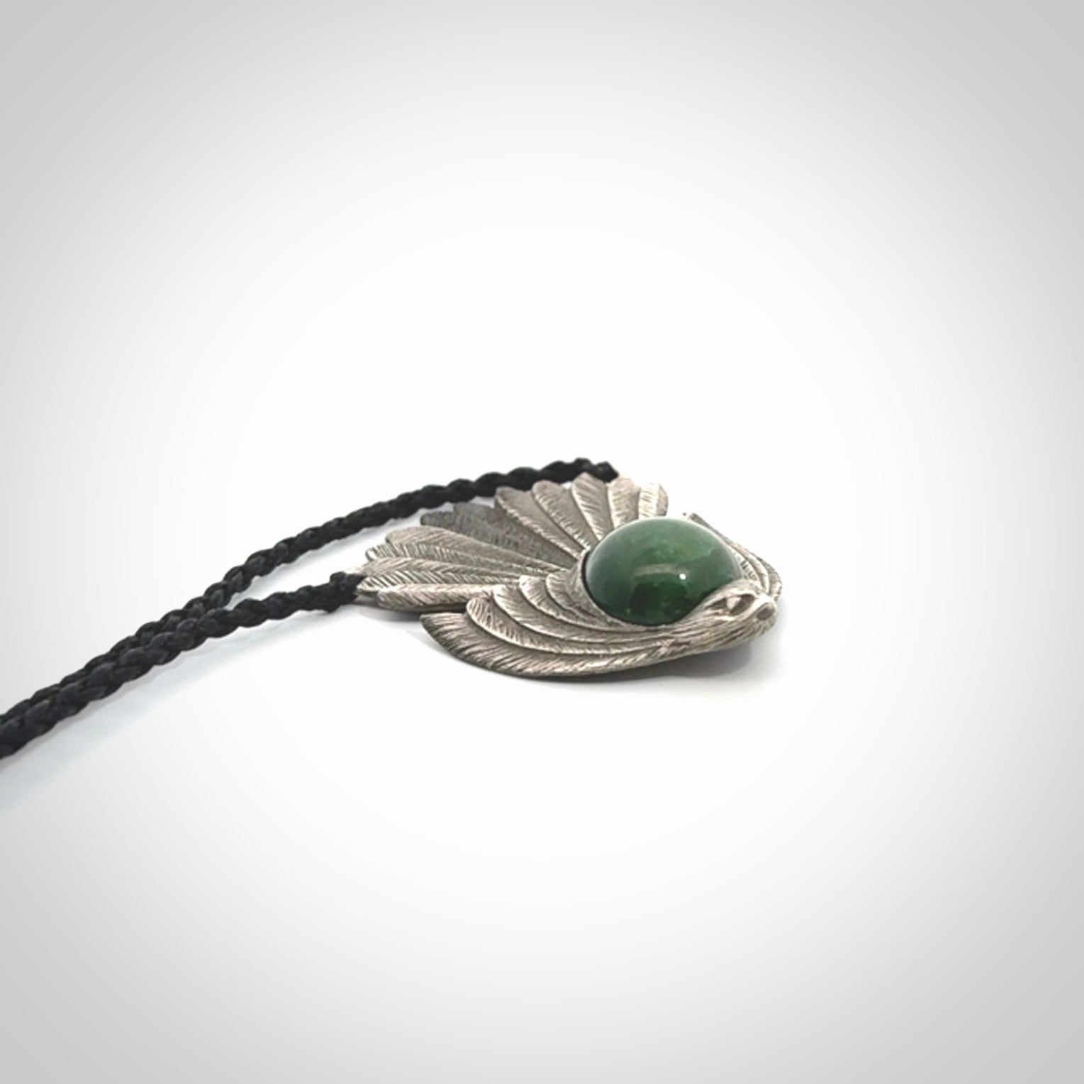 This is a hand carved Sterling Silver Fern fantail pendant with New Zealand Jade insert. This is a medium sized necklace and is provided with an adjustable black cord.