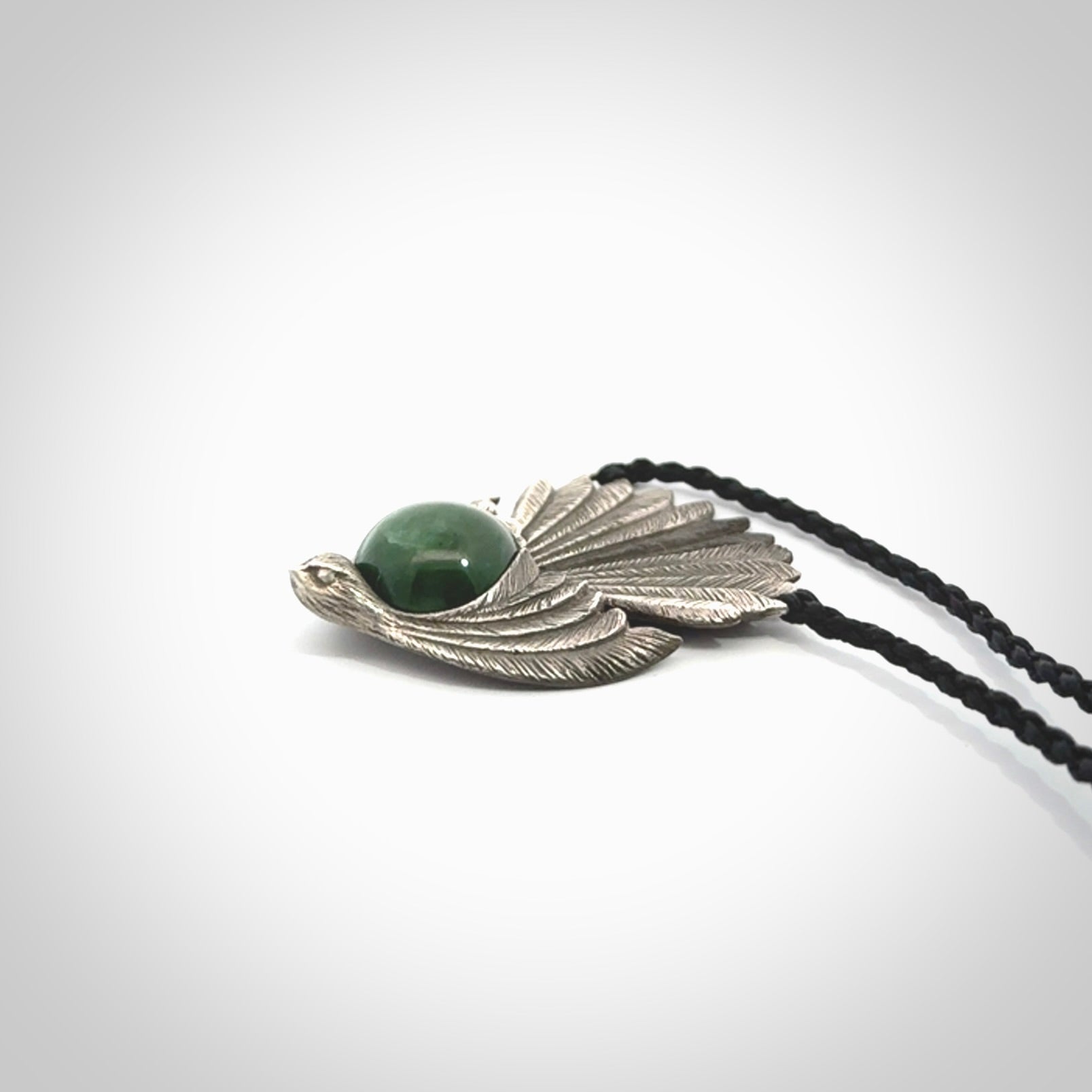 This is a hand carved Sterling Silver Fern fantail pendant with New Zealand Jade insert. This is a medium sized necklace and is provided with an adjustable black cord.