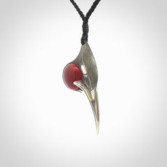 This is a hand carved Sterling Silver Huia bird pendant with Red Cats Eye insert. This is a medium sized necklace and is provided with an adjustable black cord.
