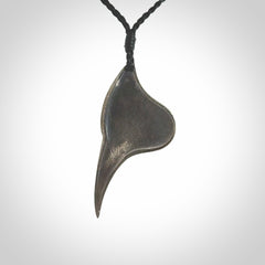 This is a hand carved Sterling Silver Huia bird pendant with Red Cats Eye insert. This is a medium sized necklace and is provided with an adjustable black cord.