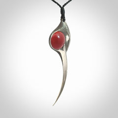 This is a hand carved Sterling Silver Huia bird pendant with Red Cats Eye insert. This is a large sized necklace and is provided with an adjustable black cord.