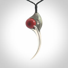 This is a hand carved Sterling Silver Huia bird pendant with Red Cats Eye insert. This is a large sized necklace and is provided with an adjustable black cord.