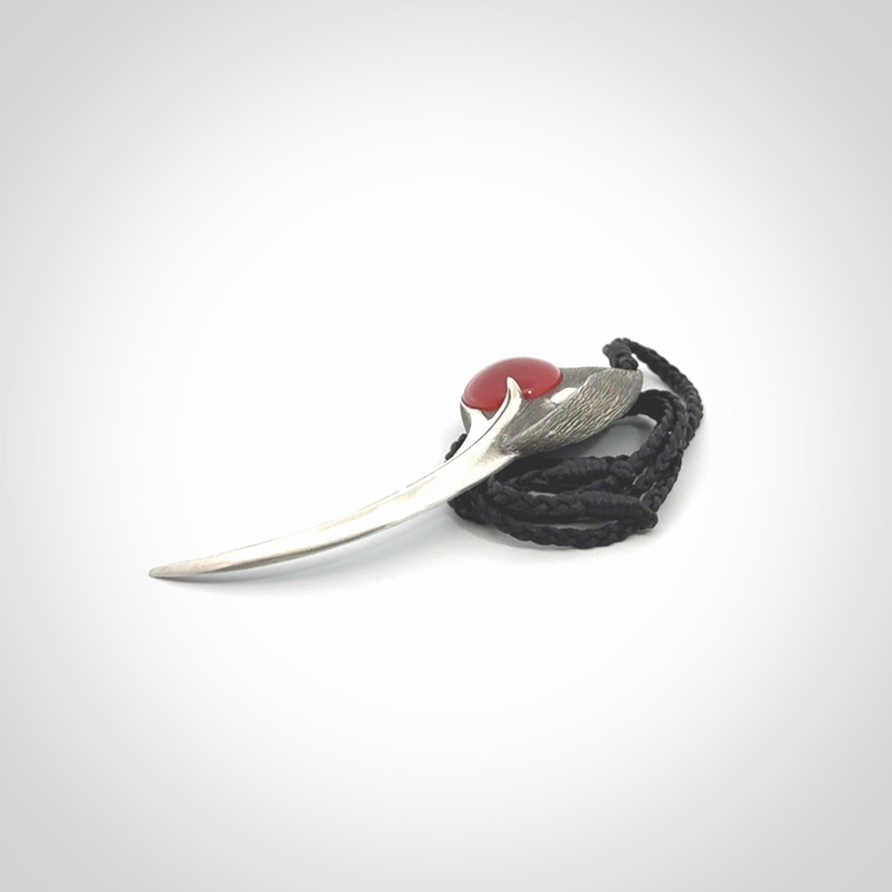 This is a hand carved Sterling Silver Huia bird pendant with Red Cats Eye insert. This is a large sized necklace and is provided with an adjustable black cord.