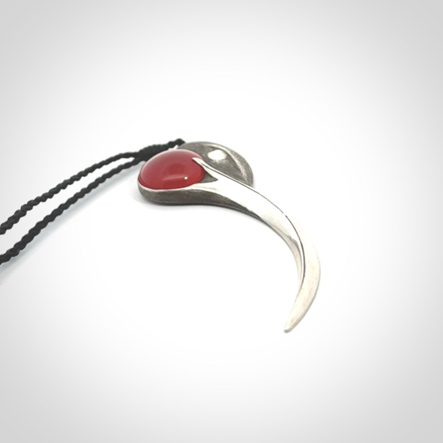 This is a hand carved Sterling Silver Huia bird pendant with Red Cats Eye insert. This is a large sized necklace and is provided with an adjustable black cord.