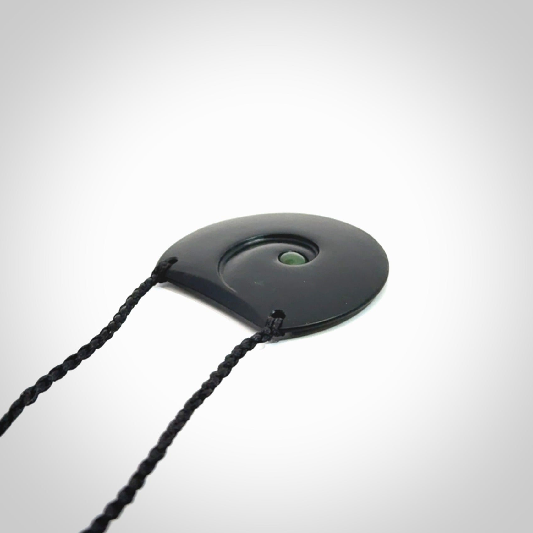 This is a hand carved Black Jade drop pendant with New Zealand Jade insert. This is a medium sized necklace and is provided with an adjustable black cord.