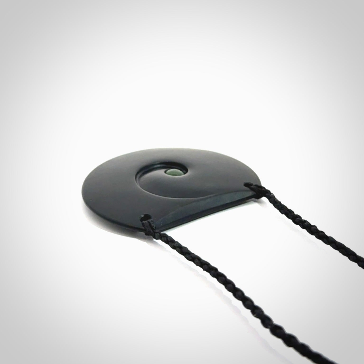 This is a hand carved Black Jade drop pendant with New Zealand Jade insert. This is a medium sized necklace and is provided with an adjustable black cord.