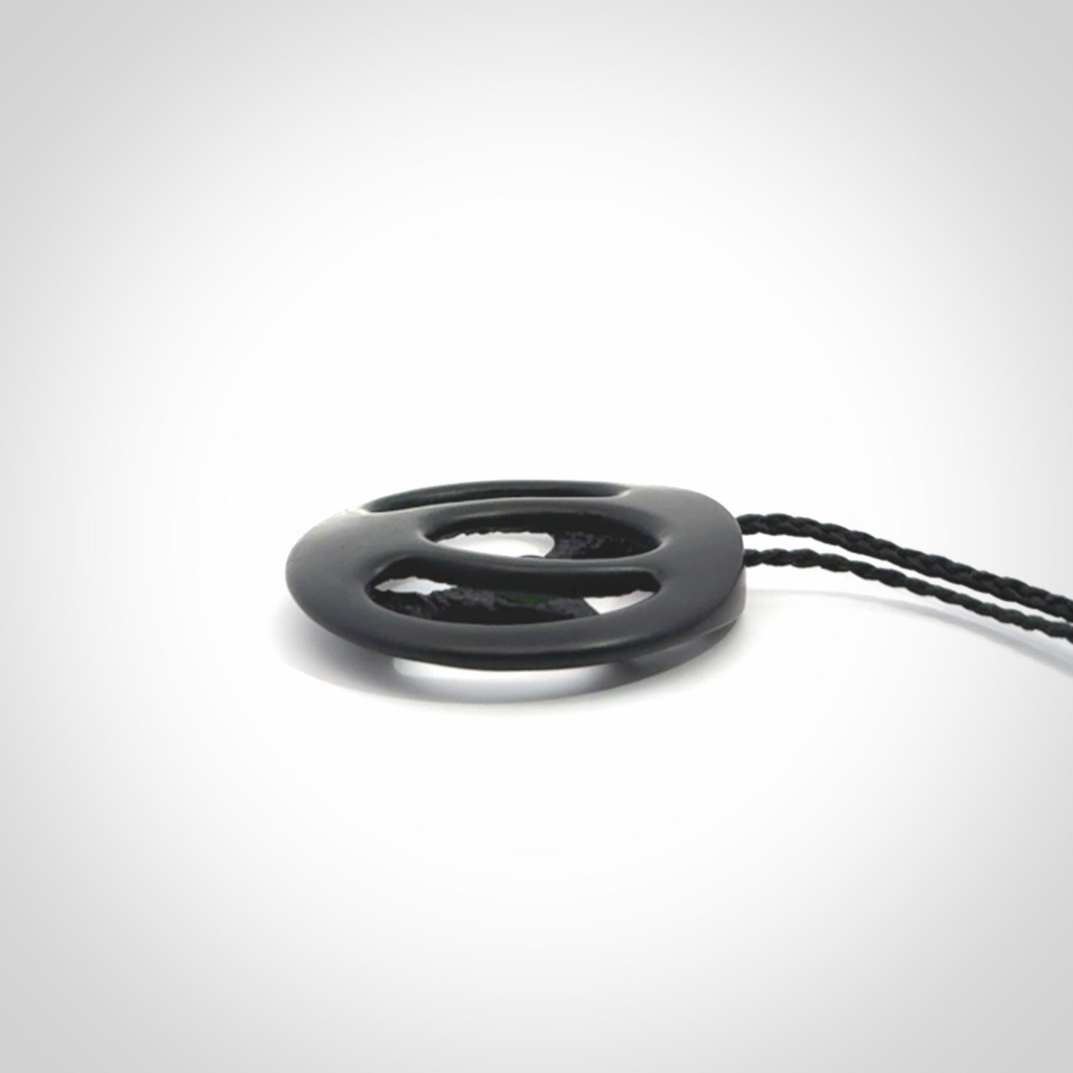 This is a hand carved Black Jade drop pendant with New Zealand Jade insert. This is a medium sized necklace and is provided with an adjustable black cord.