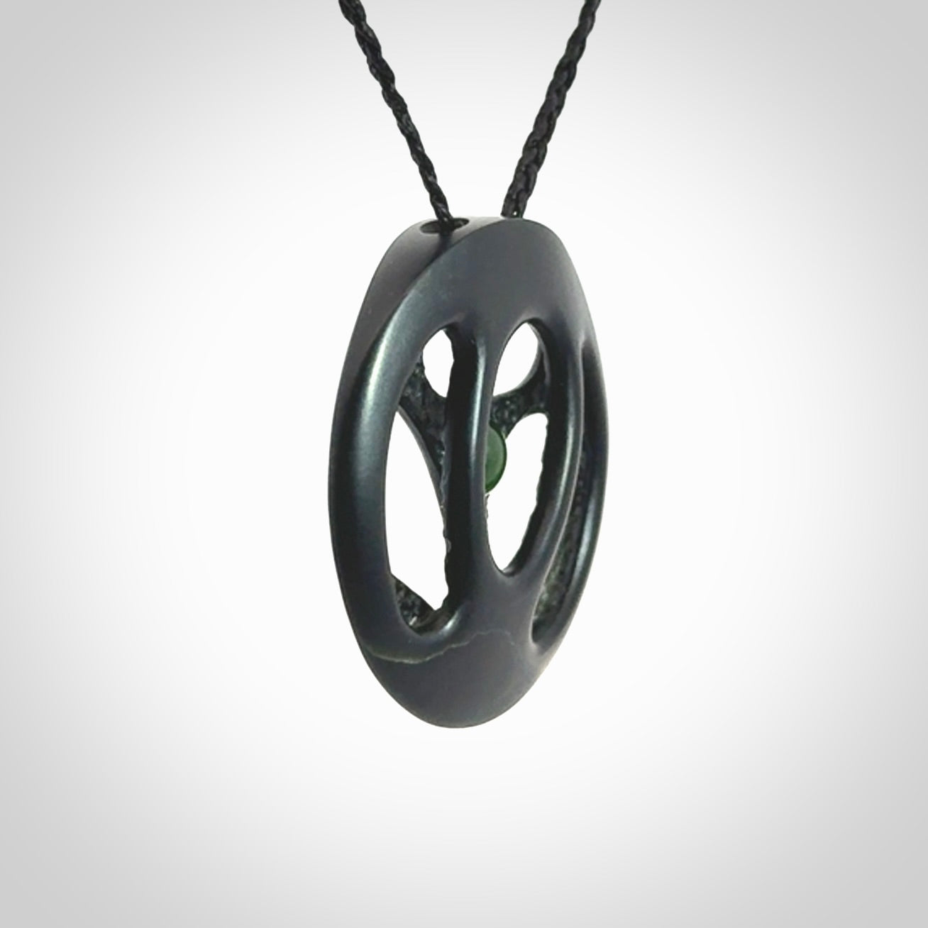 This is a hand carved Black Jade drop pendant with New Zealand Jade insert. This is a medium sized necklace and is provided with an adjustable black cord.