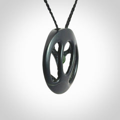 This is a hand carved Black Jade drop pendant with New Zealand Jade insert. This is a medium sized necklace and is provided with an adjustable black cord.