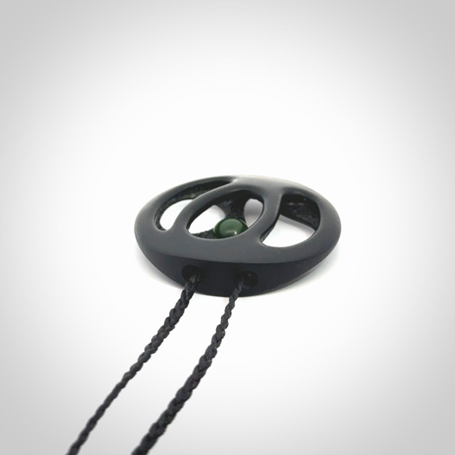 This is a hand carved Black Jade drop pendant with New Zealand Jade insert. This is a medium sized necklace and is provided with an adjustable black cord.