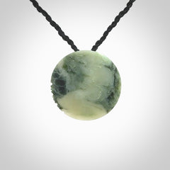 This piece is a small oval round, disc pendant hand carved in New Zealand jade.