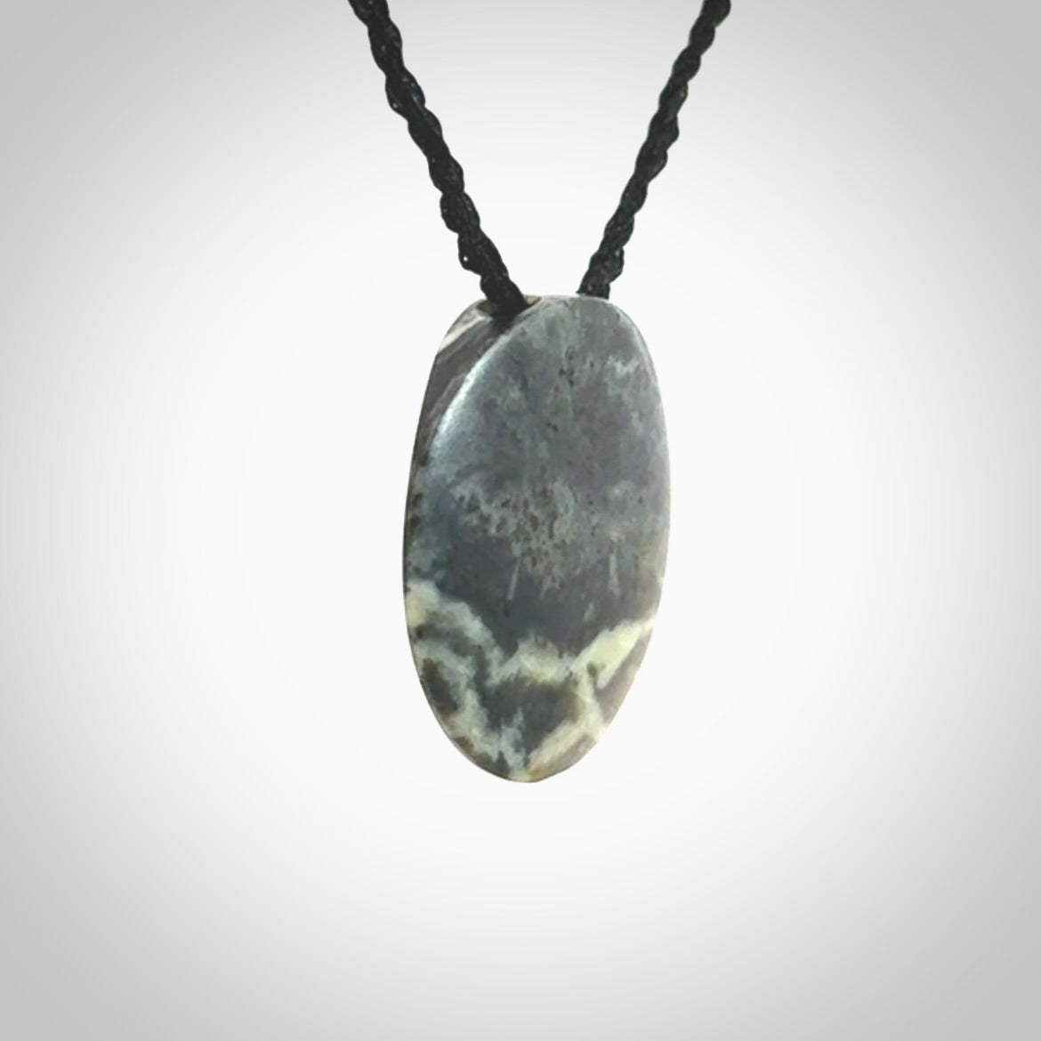 This piece is a small oval round, disc pendant hand carved in New Zealand jade.