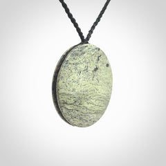 This piece is a contemporary disc pendant hand carved in New Zealand jade.