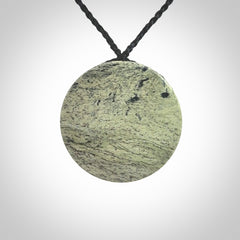 This piece is a contemporary disc pendant hand carved in New Zealand jade.