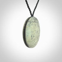 This piece is a contemporary disc pendant hand carved in New Zealand jade.