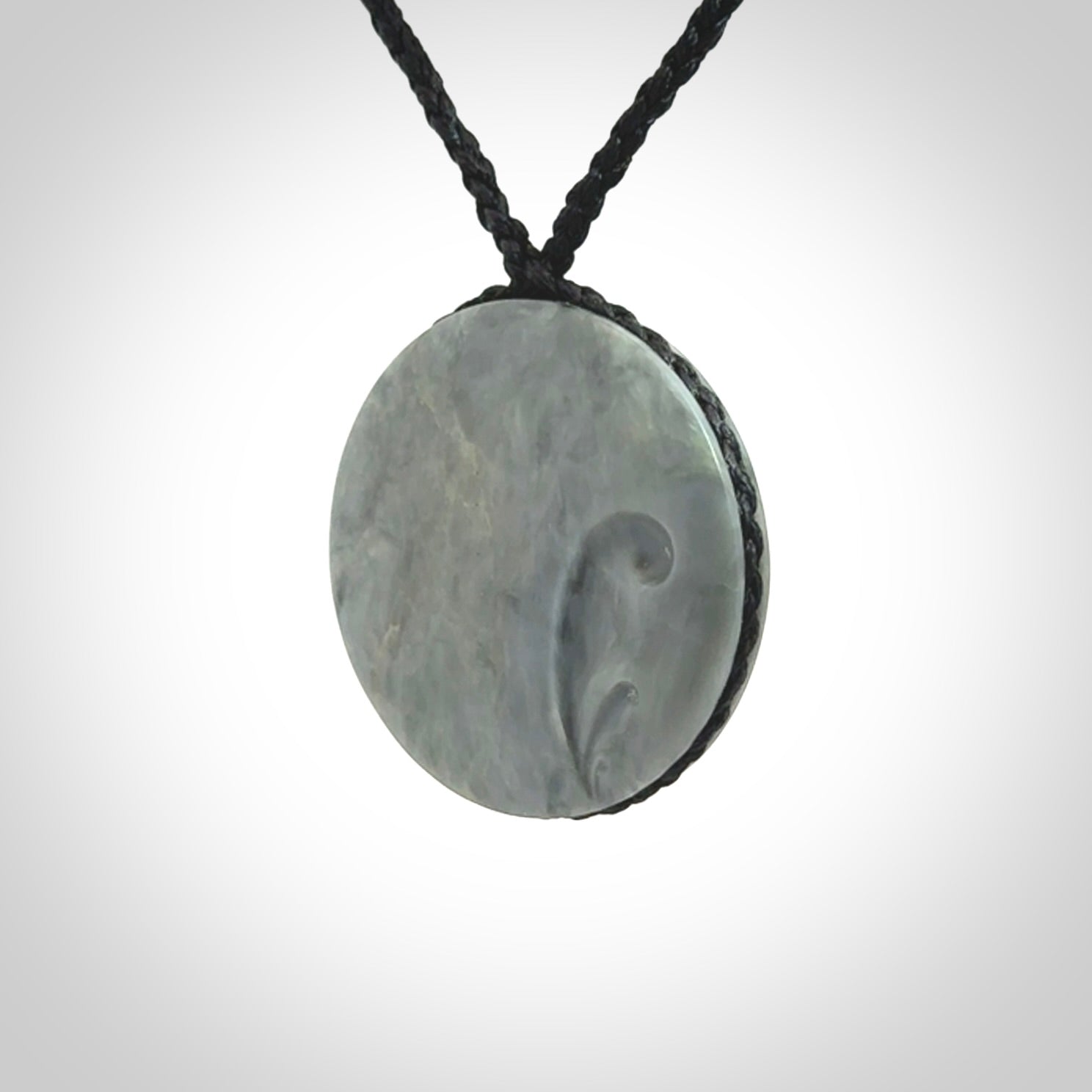 This piece is a contemporary disc pendant hand carved in New Zealand jade.