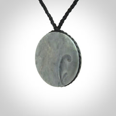 This piece is a contemporary disc pendant hand carved in New Zealand jade.
