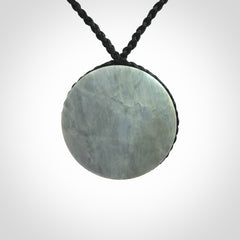 This piece is a contemporary disc pendant hand carved in New Zealand jade.
