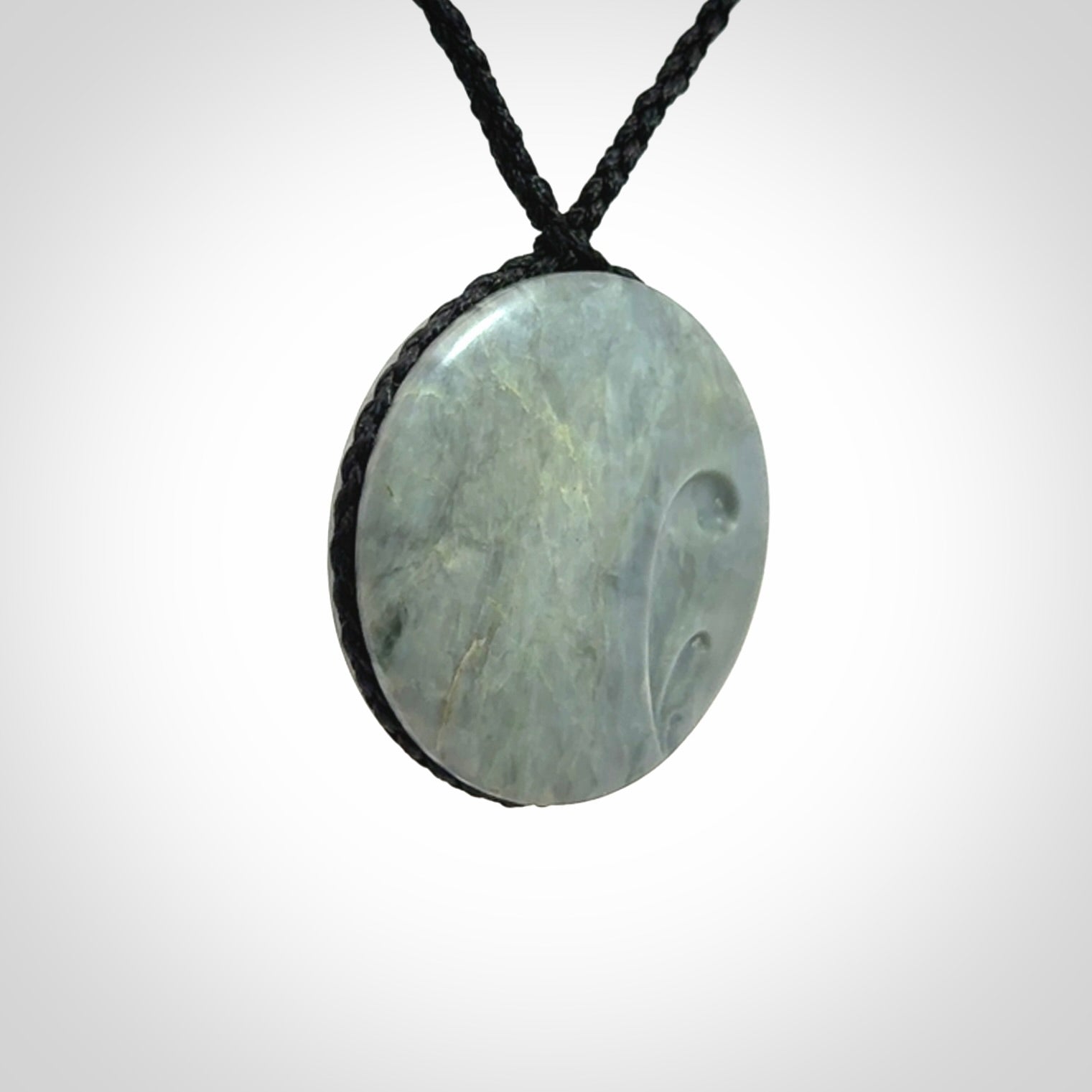 This piece is a contemporary disc pendant hand carved in New Zealand jade.