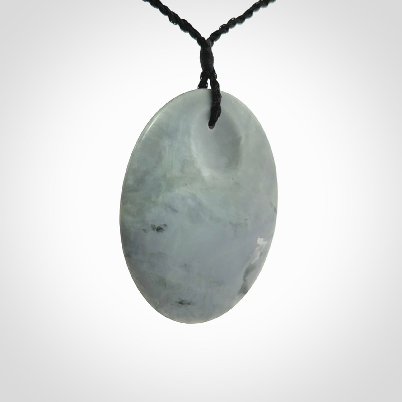 This piece is a contemporary disc pendant hand carved in New Zealand jade.