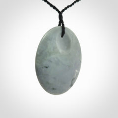 This piece is a contemporary disc pendant hand carved in New Zealand jade.