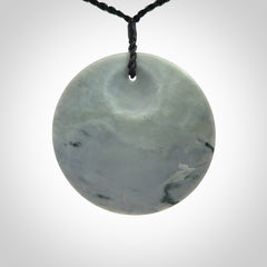 This piece is a contemporary disc pendant hand carved in New Zealand jade.