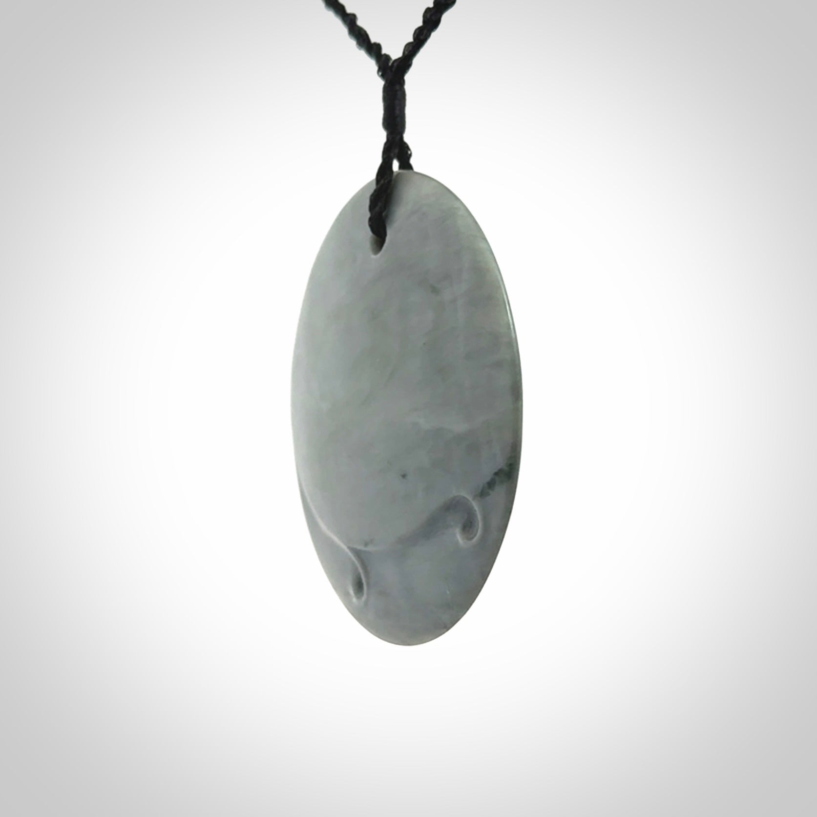 This piece is a contemporary disc pendant hand carved in New Zealand jade.