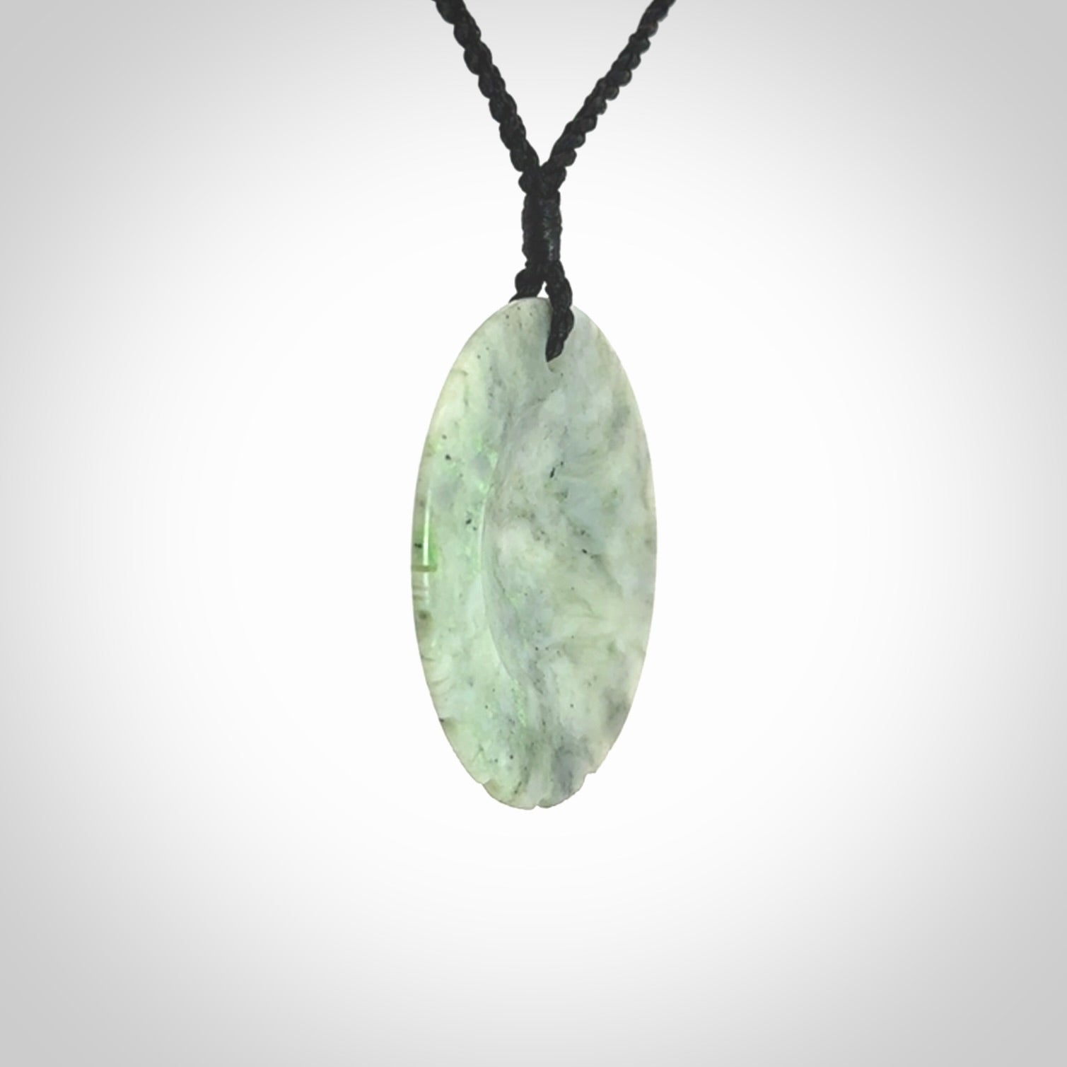 This piece is a contemporary disc pendant hand carved in New Zealand jade.