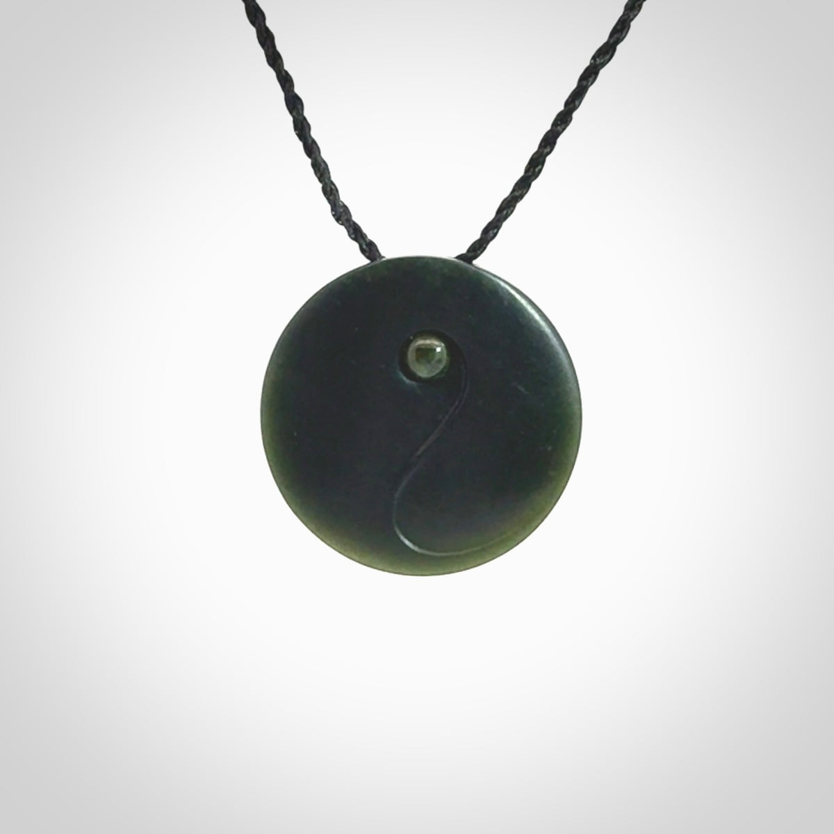 This is a hand carved Black Jade drop pendant with New Zealand Jade insert. This is a smaller sized necklace and is provided with an adjustable black cord.
