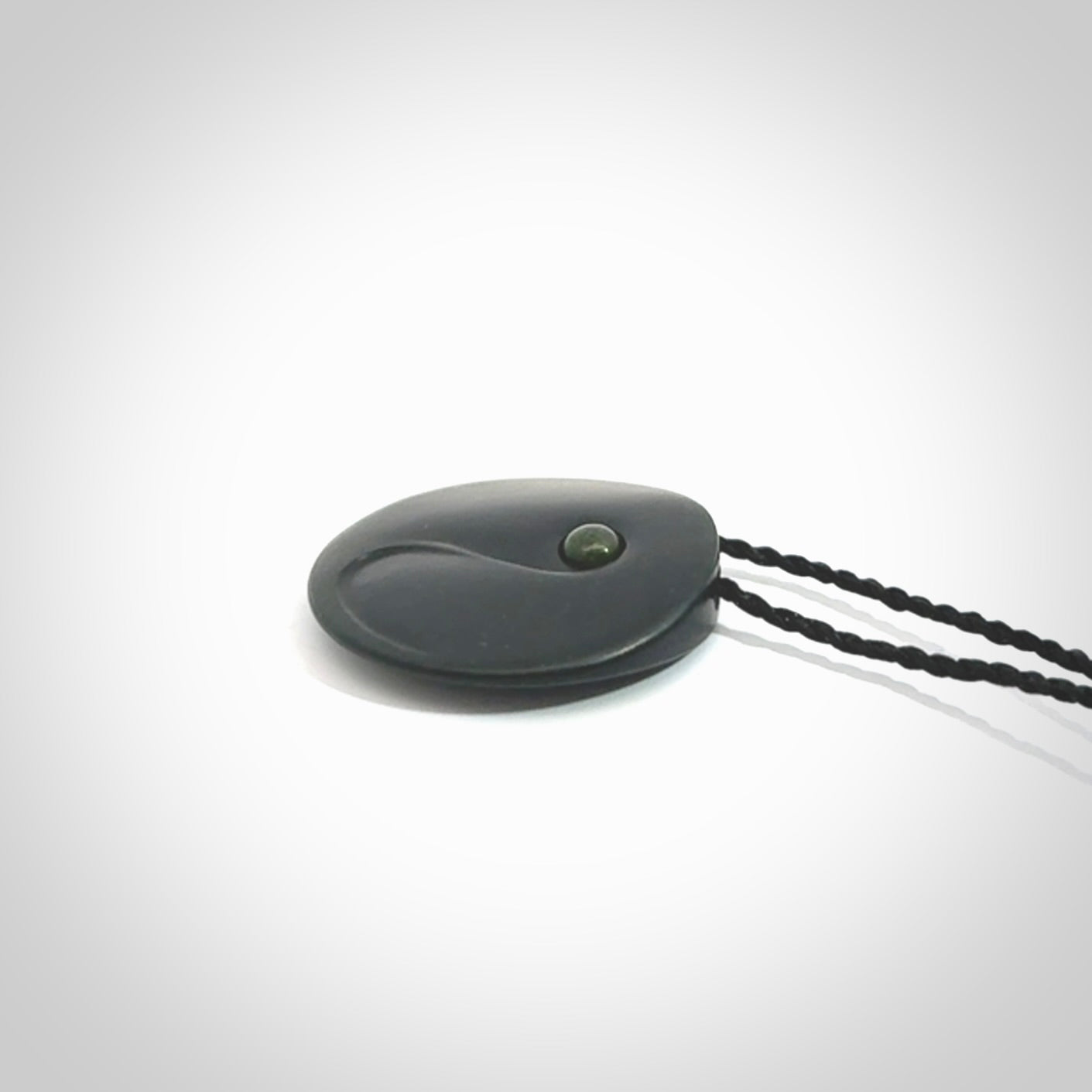 This is a hand carved Black Jade drop pendant with New Zealand Jade insert. This is a smaller sized necklace and is provided with an adjustable black cord.