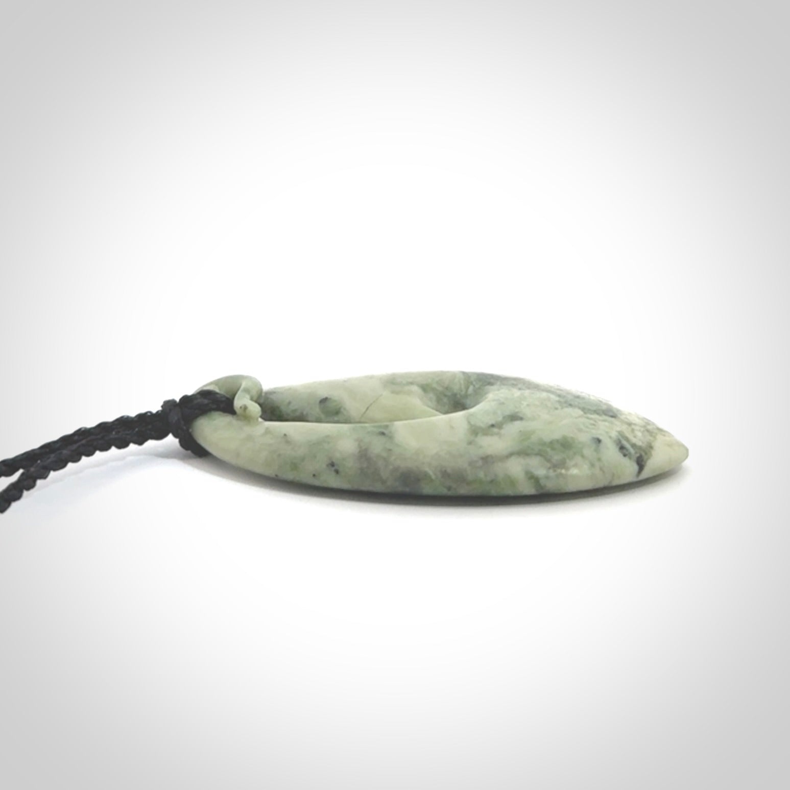 A hand carved medium New Zealand Jade Hook, Matau, necklace. The cord is adjustable