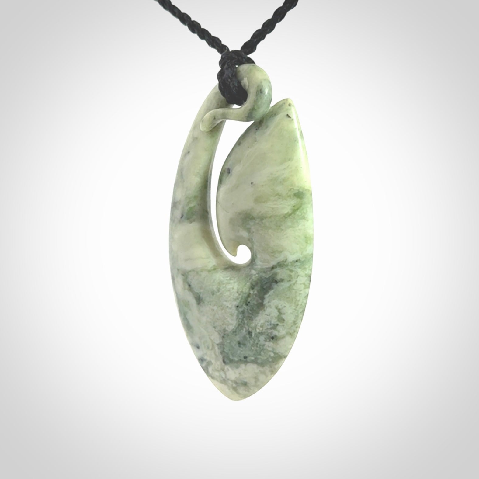 A hand carved medium New Zealand Jade Hook, Matau, necklace. The cord is adjustable