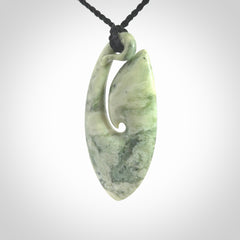 A hand carved medium New Zealand Jade Hook, Matau, necklace. The cord is adjustable