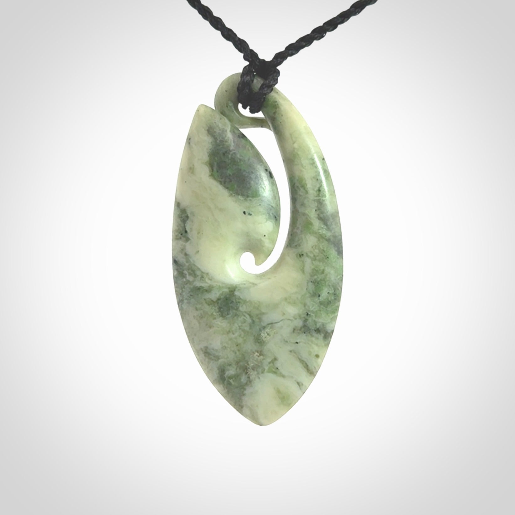 A hand carved medium New Zealand Jade Hook, Matau, necklace. The cord is adjustable